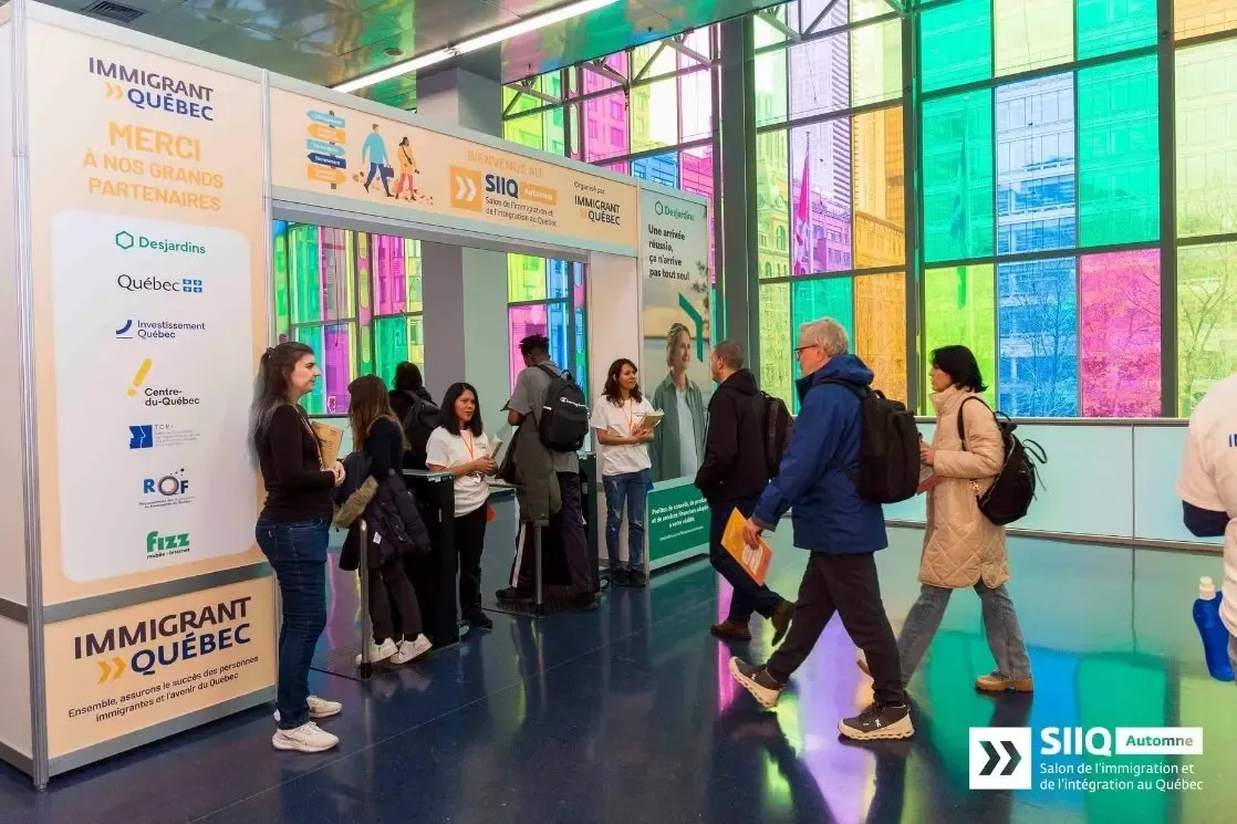 Welcome desk and attendees at the Salon de l'immigration et de l'intégration au Québec (SIIQ)